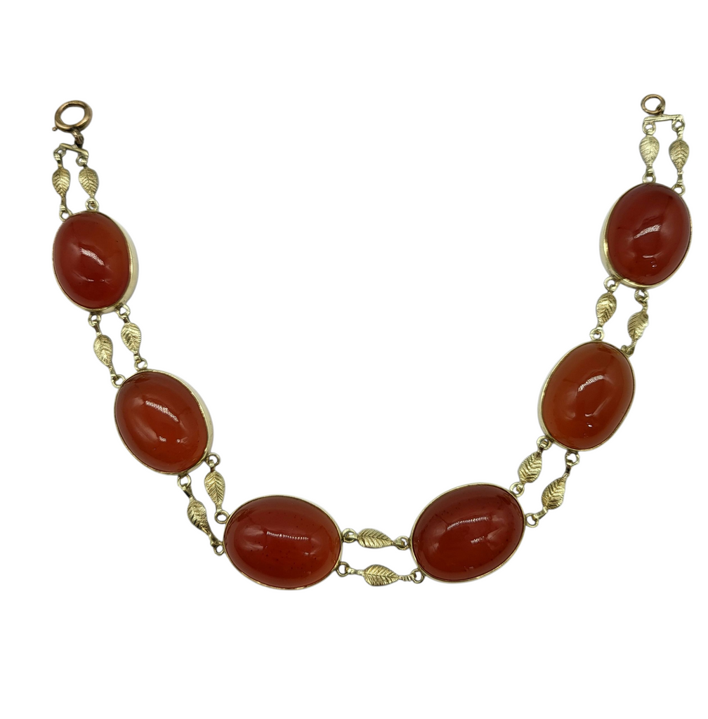 Necklace with red oval stones and gold accents on a white background