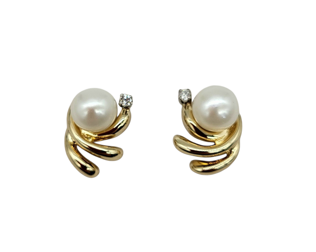 Pair of pearl earrings with gold spiral designs on a white background