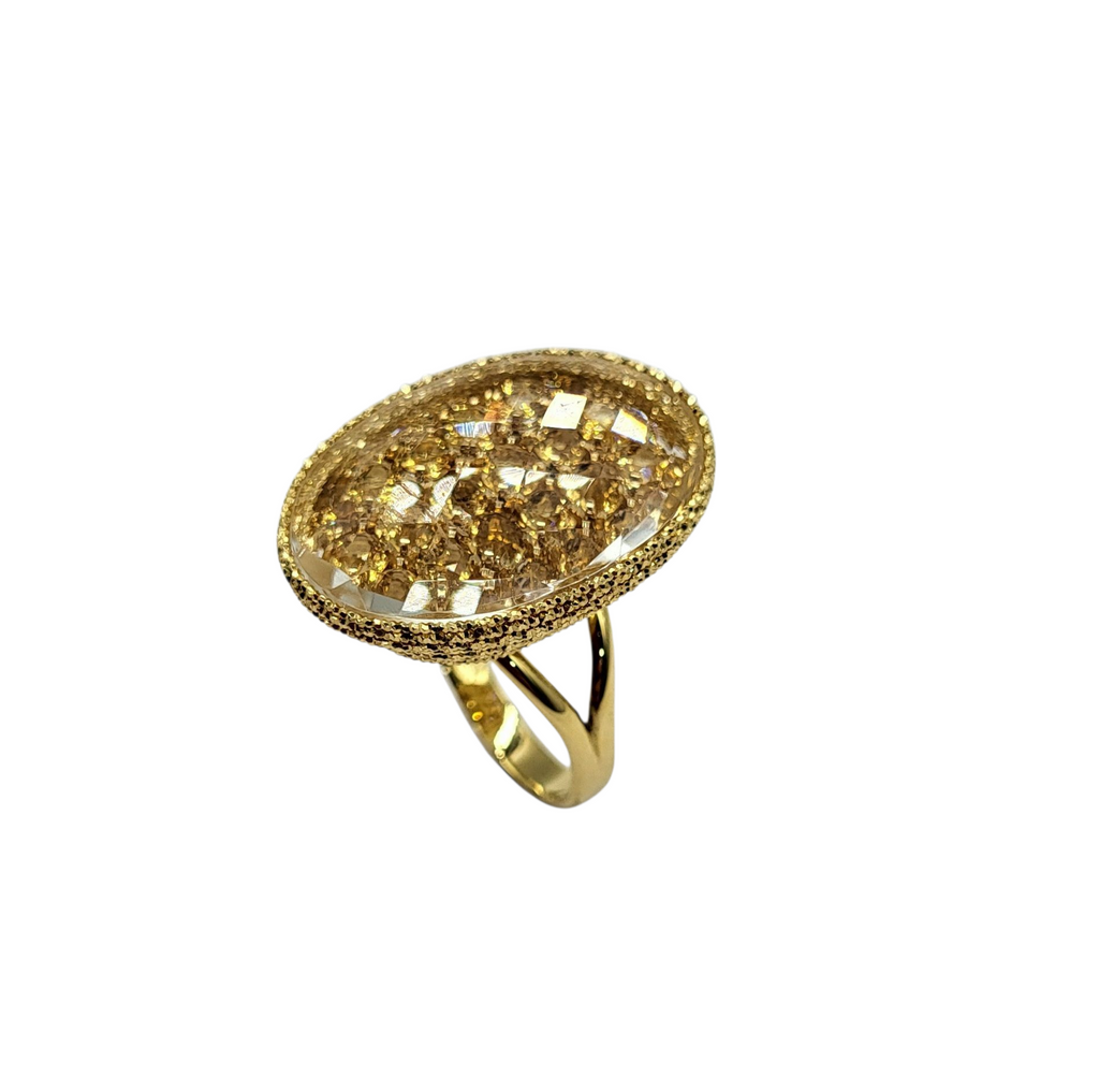 Gold ring with a large, ornate stone on a white background