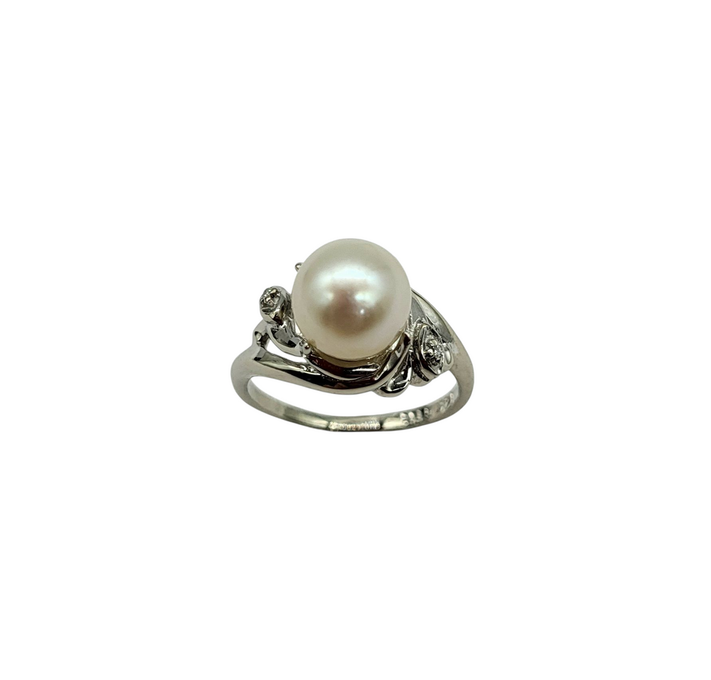 Pearl ring with silver band on a white background