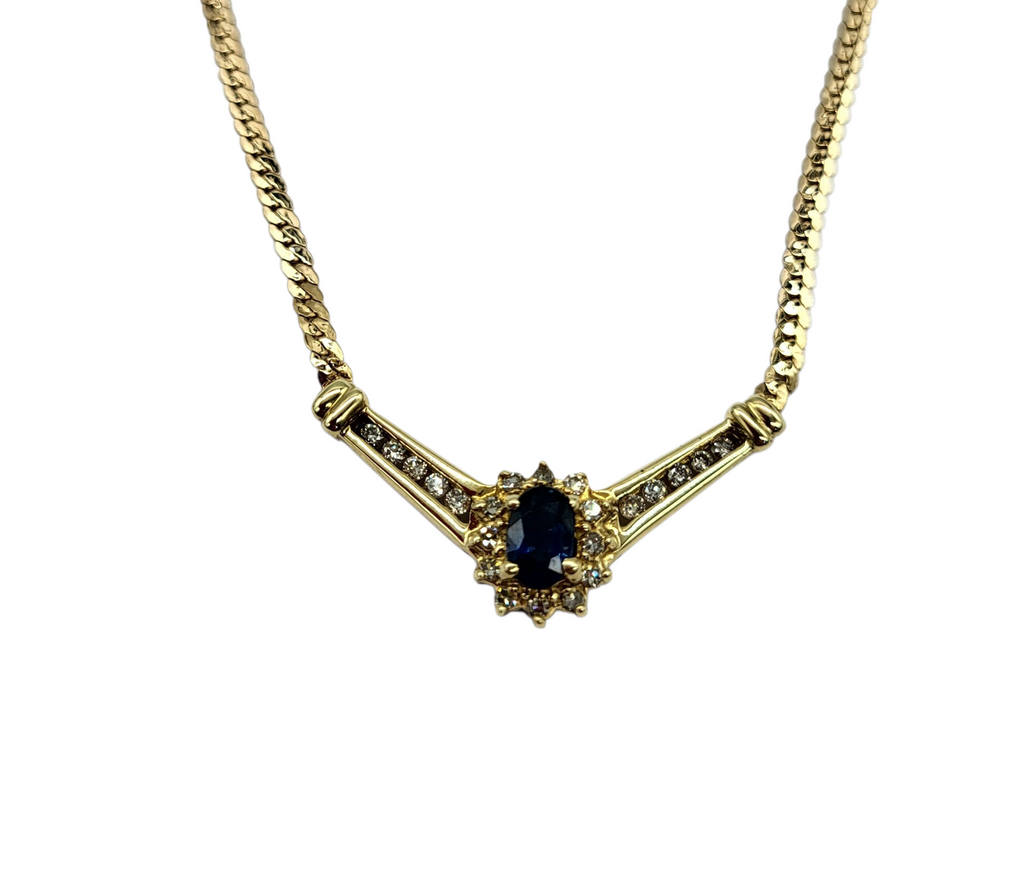 Gold necklace with a central black gemstone on a white background