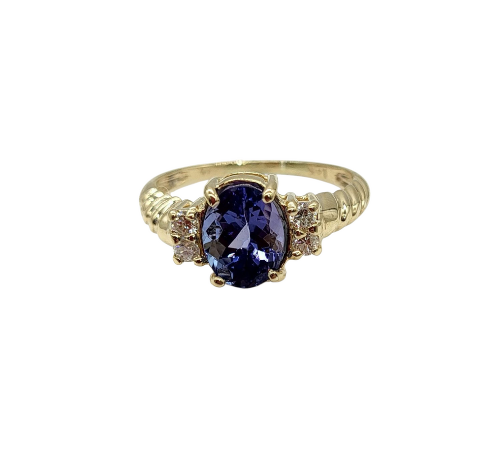 Gold ring with a purple gemstone on a white background