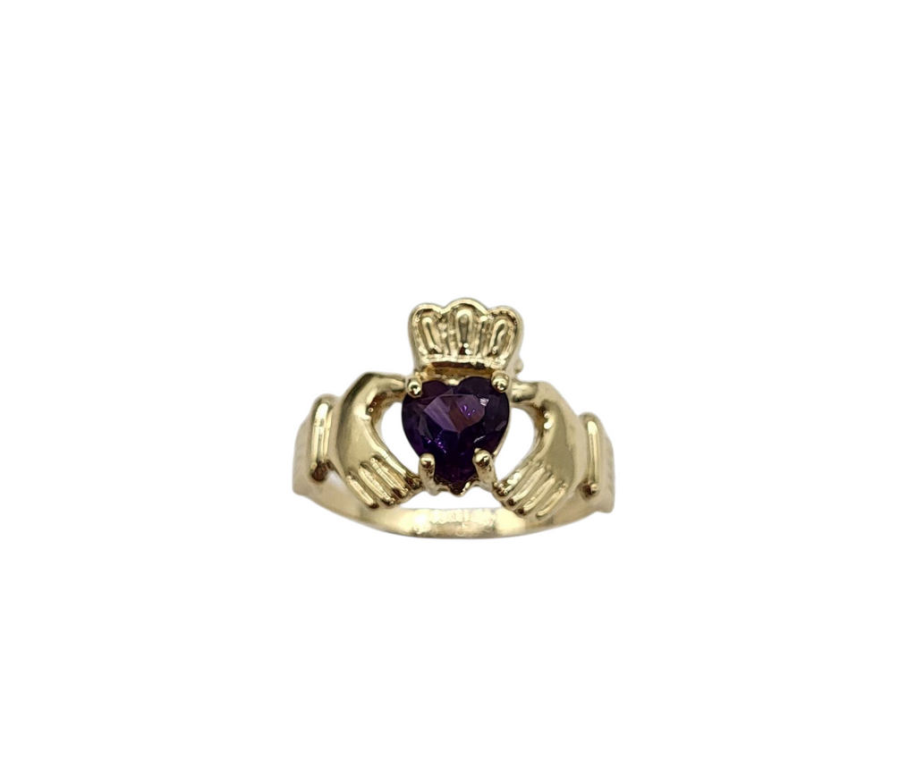 Gold ring with a heart-shaped purple gemstone on a white background