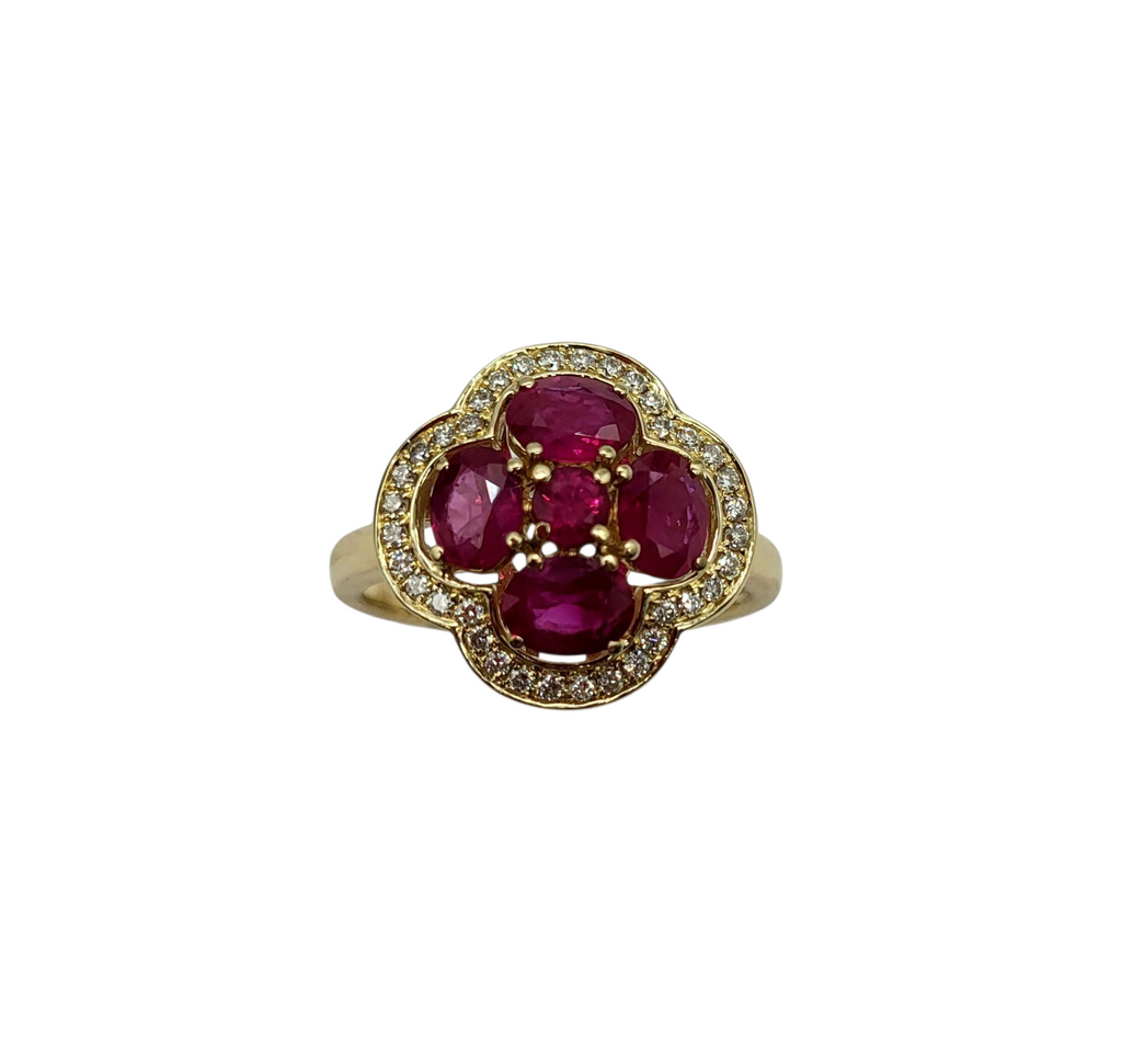 Gold ring with red gemstones on a white background