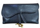 Black leather clutch bag with a gold clasp on a white background