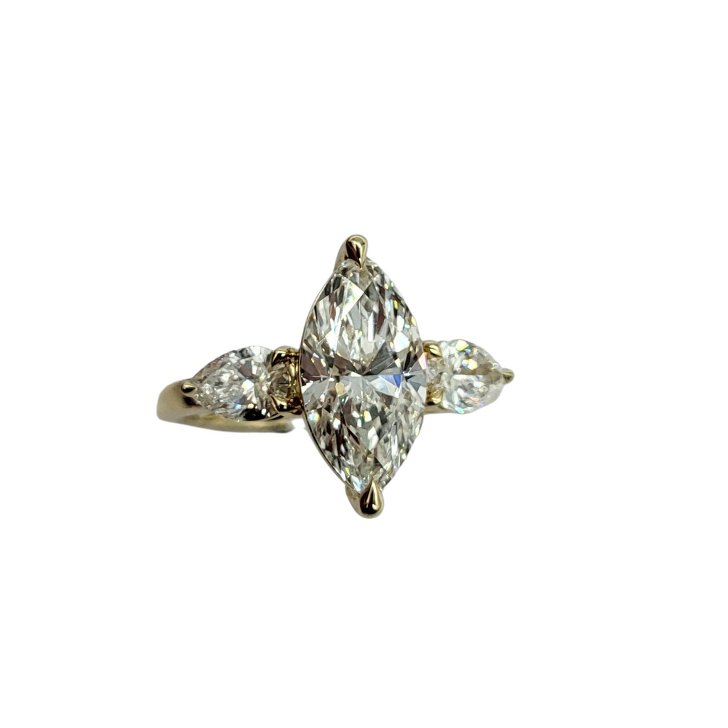 Diamond ring with pear-shaped stones on a white background
