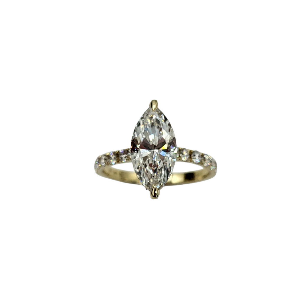 Gold ring with two pear-shaped diamonds on a white background