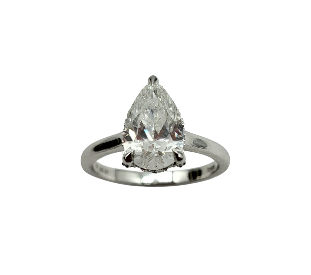 Diamond ring with pear-shaped gemstone on a white background