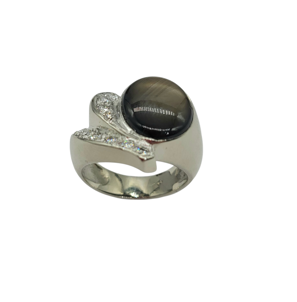 Silver ring with a black gemstone and clear stones on a white background