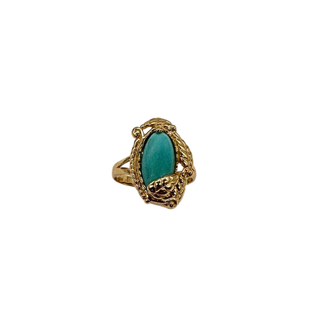 Gold ring with a green gemstone on a white background