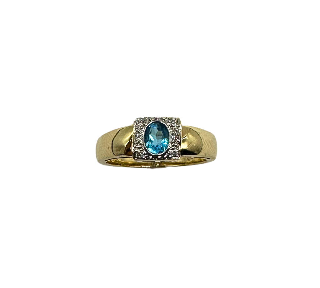 Gold ring with a blue gemstone on a white background
