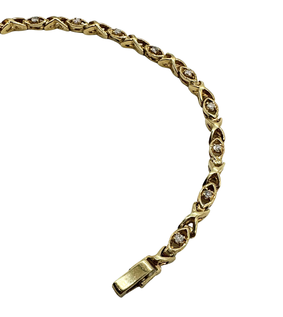 Gold bracelet with diamond accents on a white background