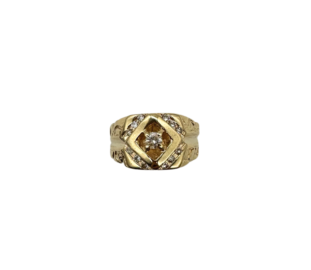 Gold ring with diamond accents on a white background