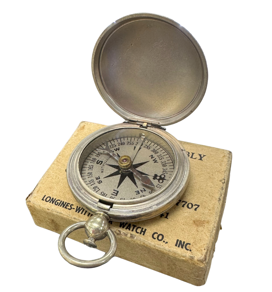 Vintage compass on a cardboard box with 'Longines' branding
