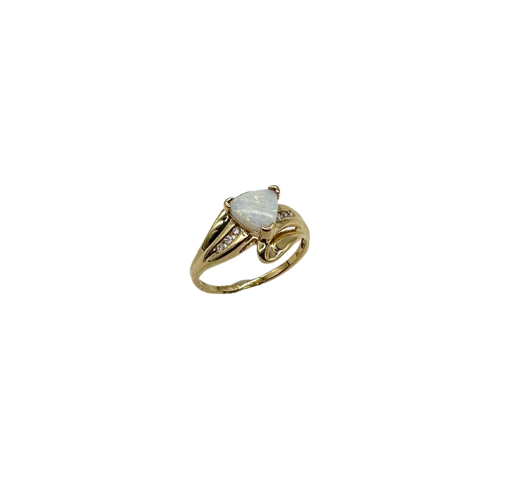 Gold ring with a heart-shaped opal stone on a white background