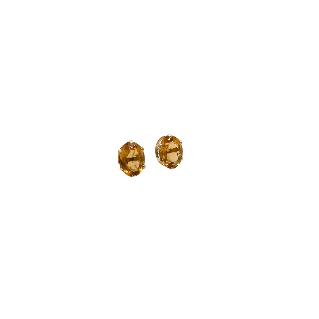 Two gold earrings with gemstones on a white background
