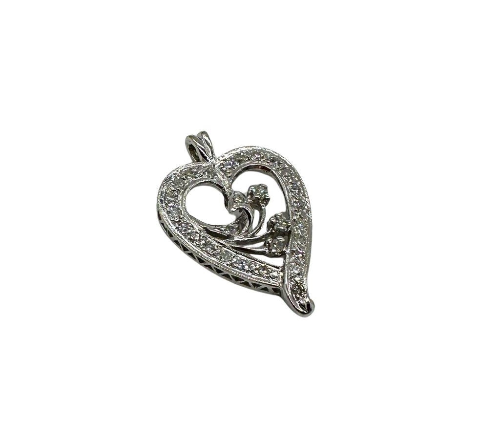 Silver heart-shaped pendant with floral design on a white background