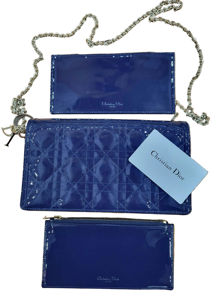 Blue quilted handbag with gold chain strap and Christian Dior tag on a wooden surface