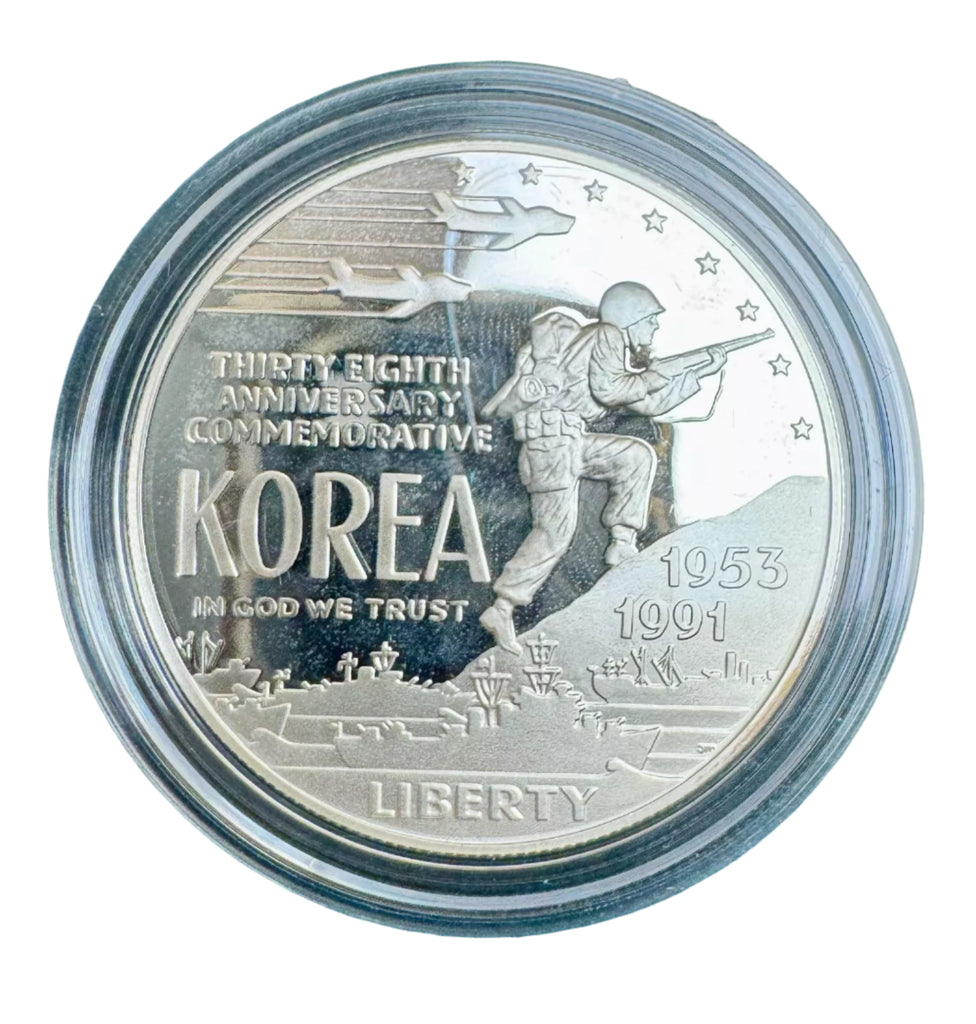 Silver commemorative coin with military design and text on a blue background