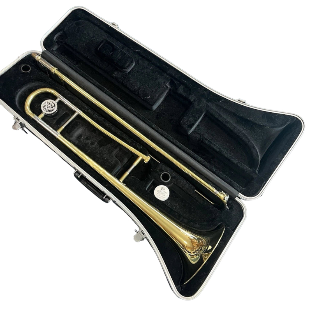 Gold trumpet in a black case on a blue surface