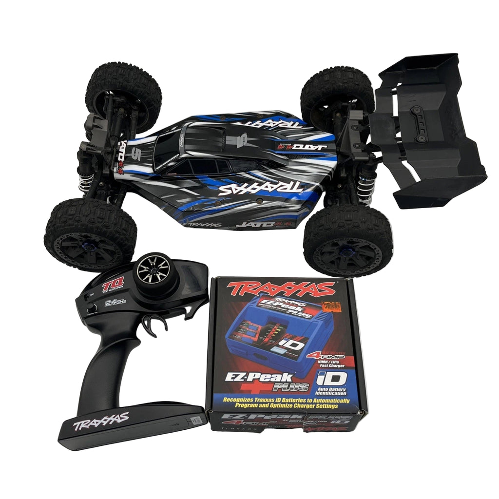 Traxxas remote control car with battery pack and charger on a white background