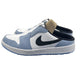 White and blue sneaker with a black swoosh logo on a black box against a light gray background