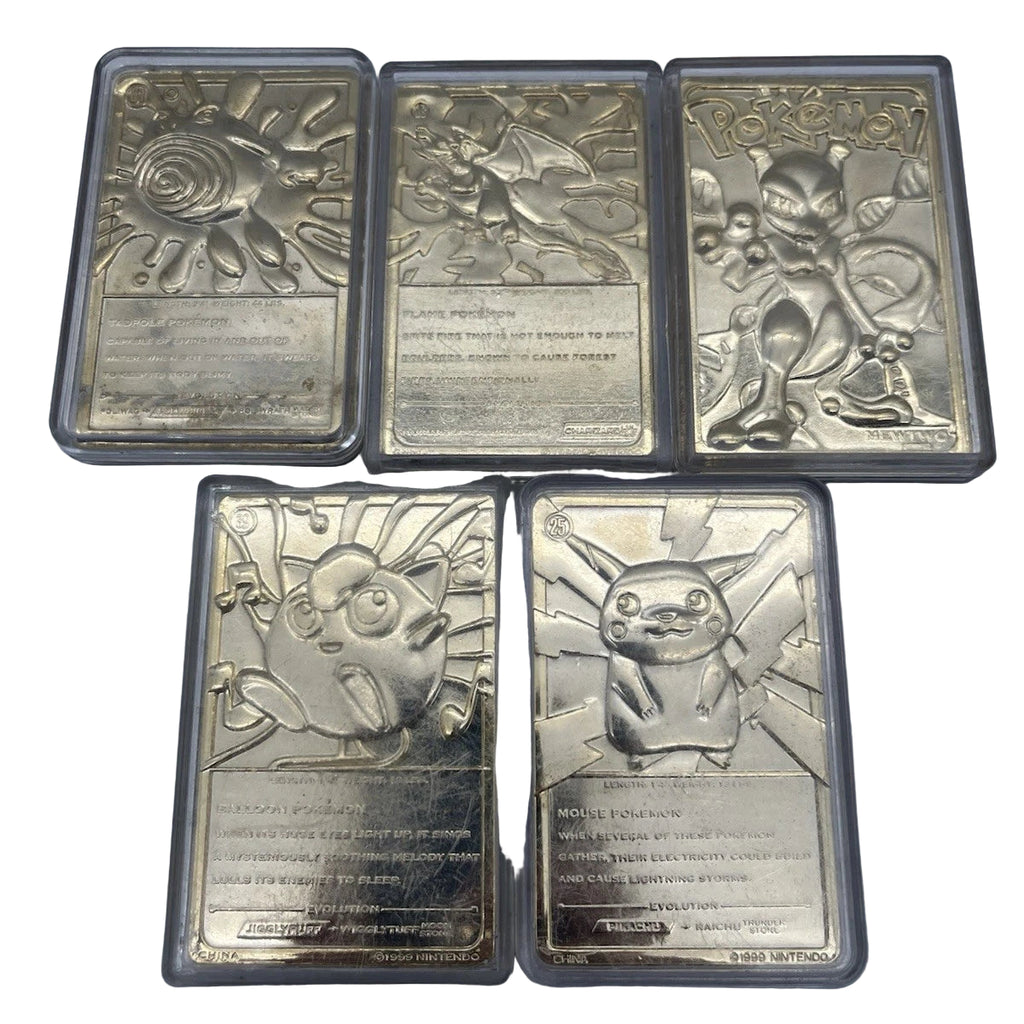 Five silver collectible cards with unique designs on a gray surface