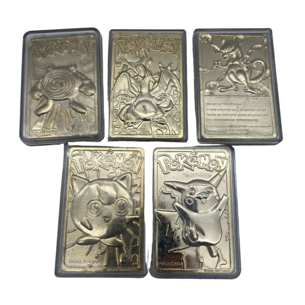 Five metallic Pokémon cards on a gray surface