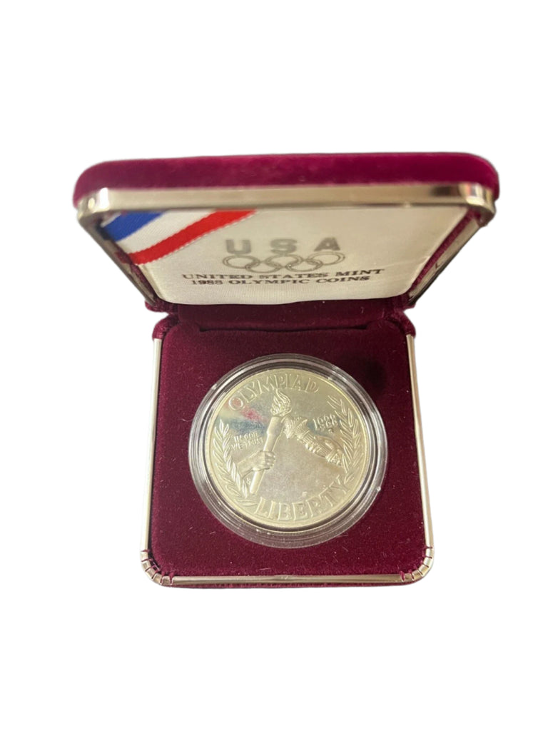 Silver coin in a U.S. Mint box on a dark surface