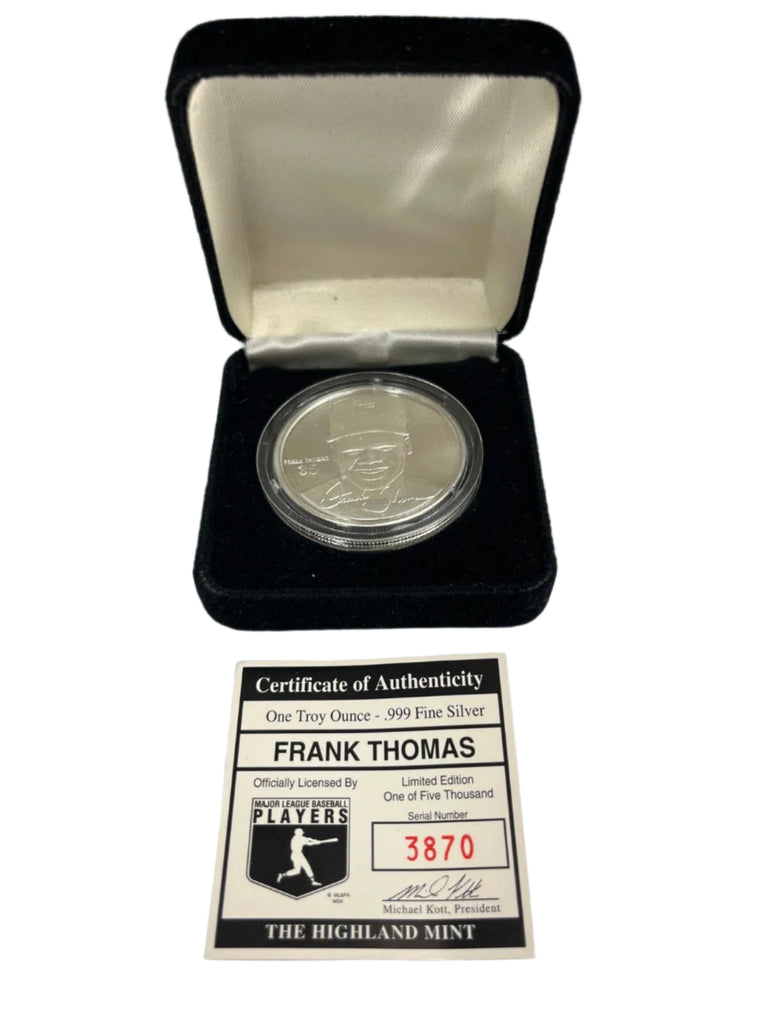 Silver coin with certificate of authenticity in a display case on a gray background