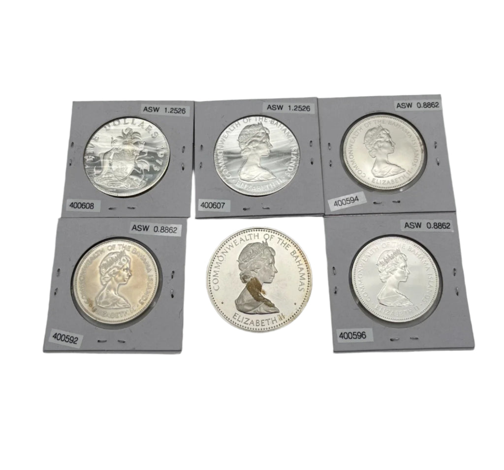 Set of six silver coins in protective holders on a gray surface