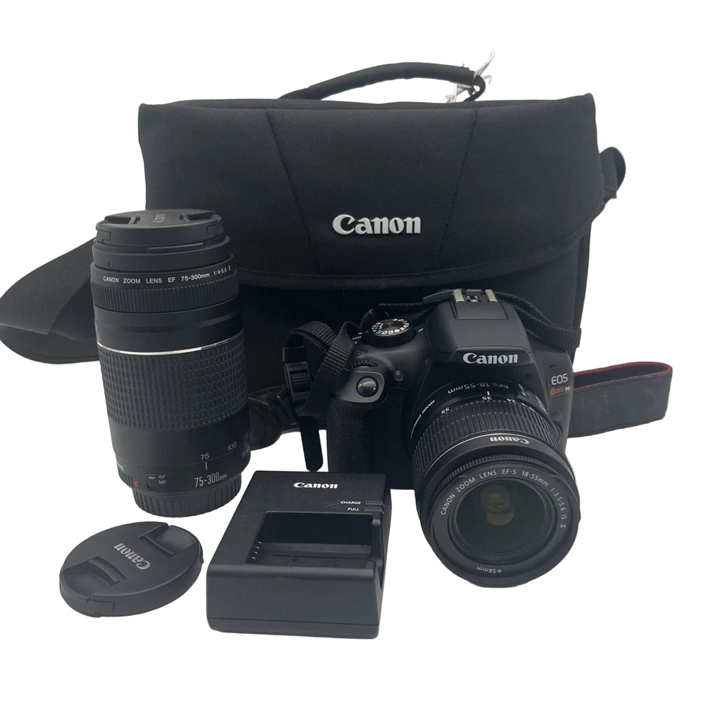 Canon camera with lens, battery charger, and case on a white background