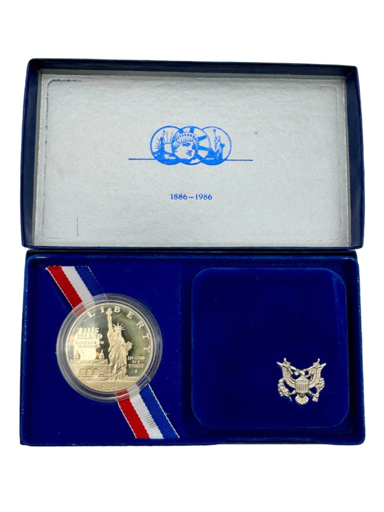 Gold coin in a blue display case with a ribbon and U.S. Treasury emblem.